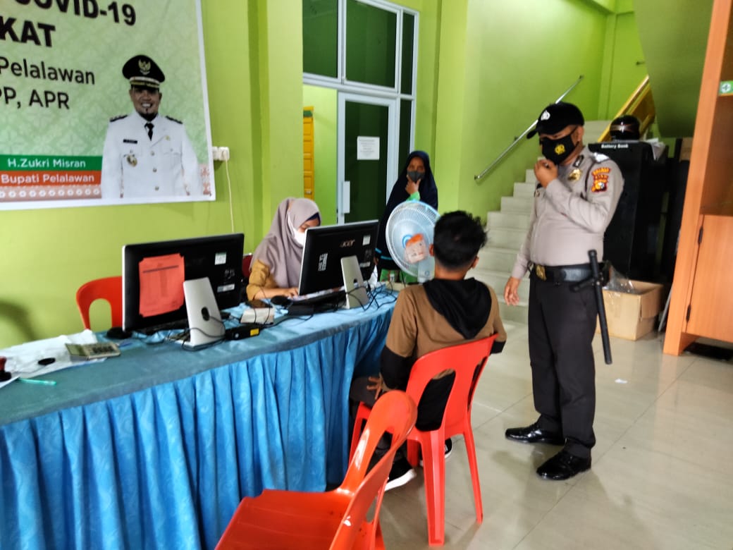 Personil Polsek Kuala Kampar Dampingi Nakes Dalam Kegiatan Vaksinasi di Puskesmas
