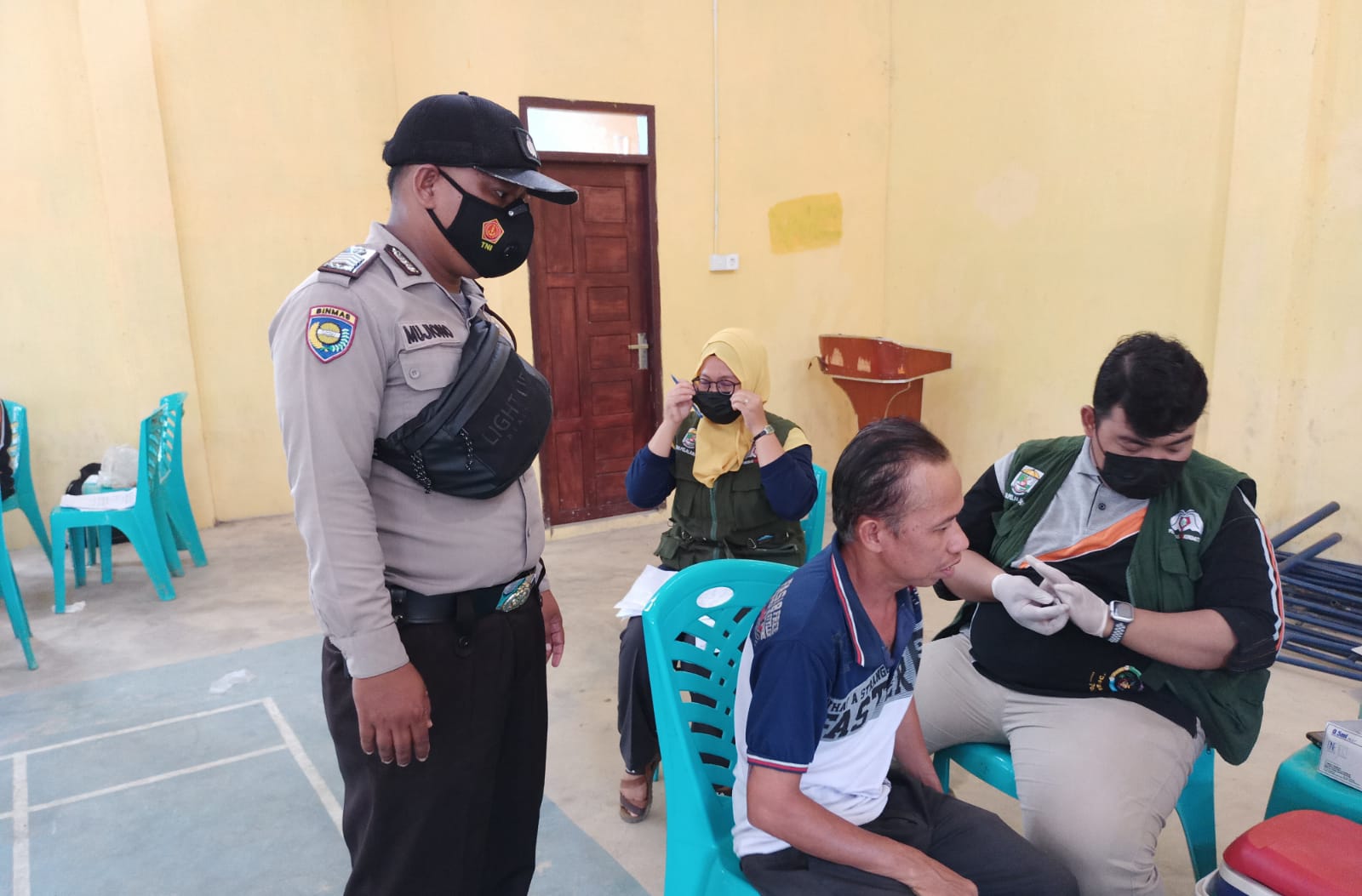 Rutin, Bhabinkamtibmas Polsek Kerumutan Kawal Vaksinasi di Desa Binaannya