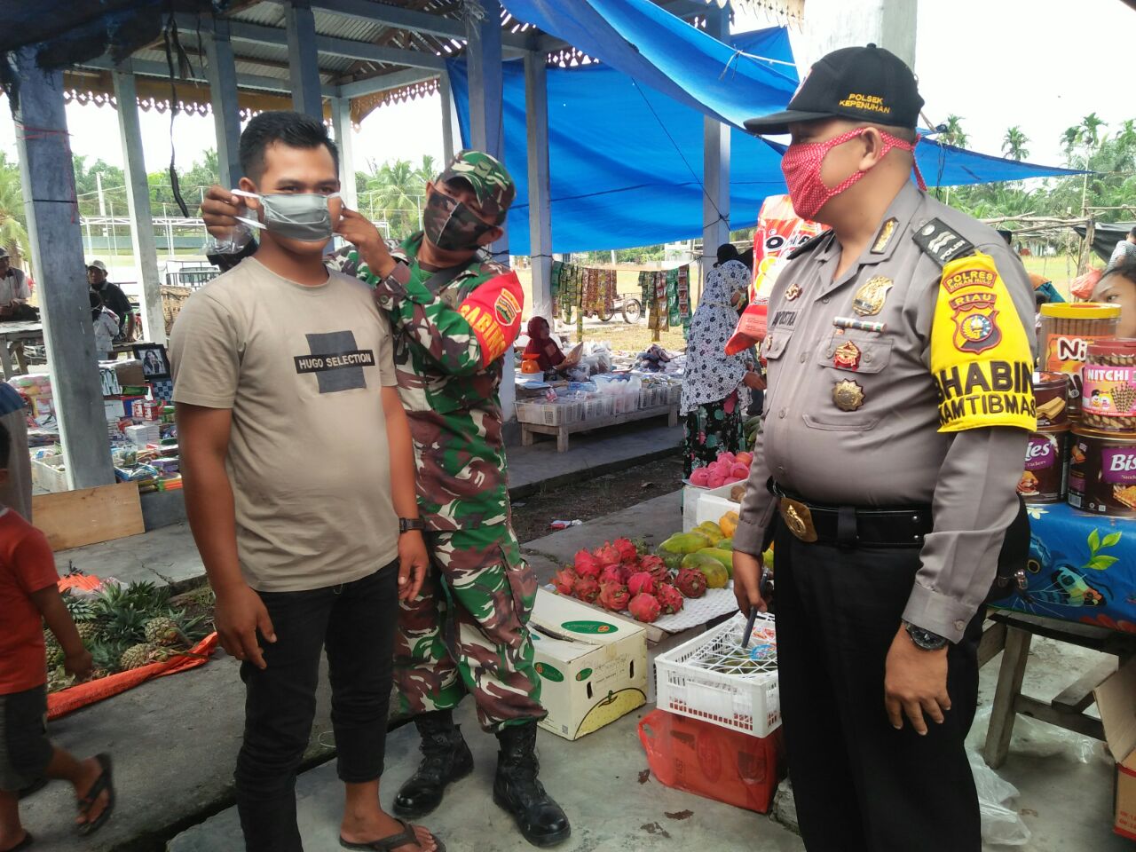 Babinsa Koramil 14/Kepenuhan Bersama Pelajar SMK Negeri 2 Kepenuhan Bagi Masker di Pasar