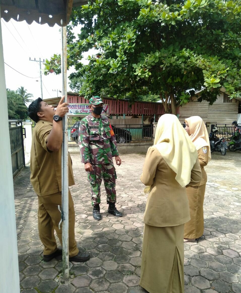 Babinsa Koramil 04/PKL Kuras Imbau Aparat Desa dan Warga Pasang Bendera yang Layak